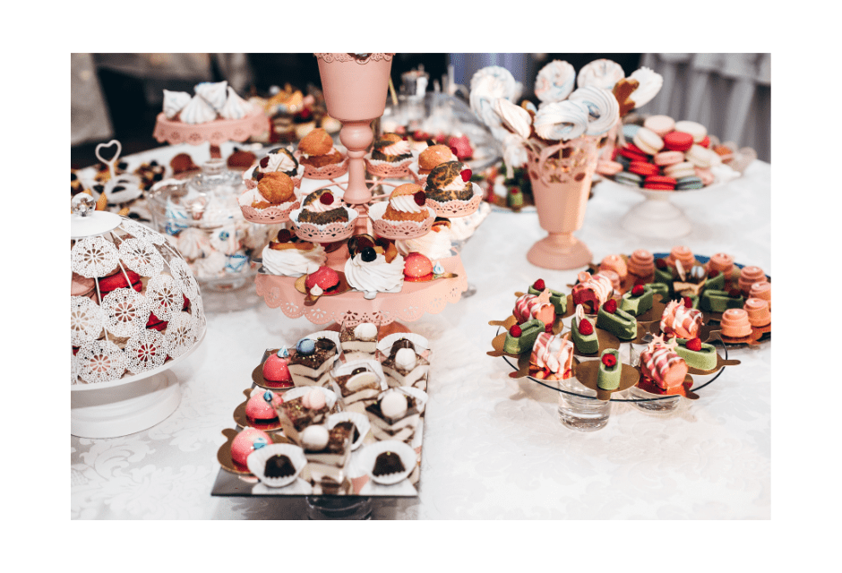 Romantic pink dessert table with cupcakes, macarons, meringues, chocolate desserts, fruit-topped sweets, and elegant bite-sized treats for a bridal shower or anniversary.