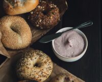 Assorted plain, sesame, everything, multigrain and blueberry bagels served with a bowl of flavored cream cheese.
