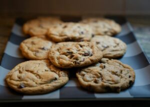 Freshly baked chocolate chip cookies arranged on a serving tray, featuring golden edges, soft centers, and chocolate chips.