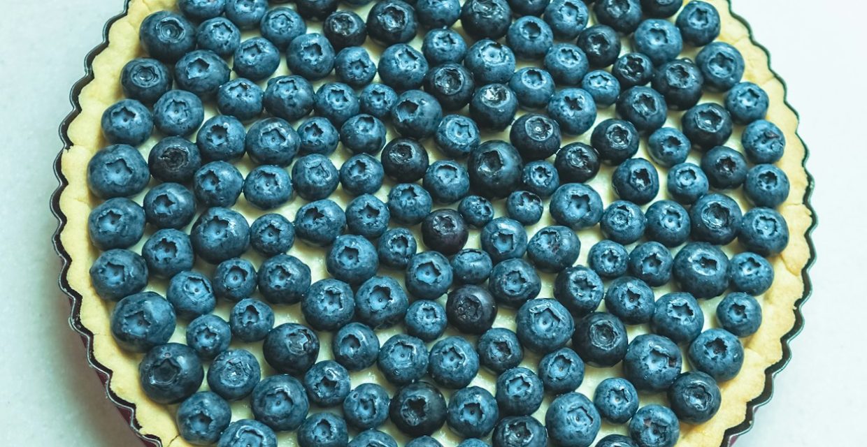 Fresh blueberry tart with a buttery pastry crust, smooth vanilla custard filling, and a generous topping of ripe blueberries, perfect for catered dessert tables in Charleston, SC.