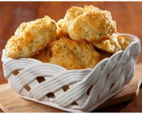 Freshly baked cheddar herb biscuits served warm in a basket for catering, brunch, weddings, and special events by Bites of Charleston in Charleston, SC.