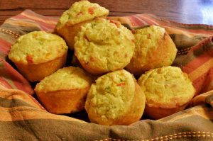 Fresh baked savory cornbread muffins with cheddar cheese, peppers, and herbs, served warm as a Southern side for catered weddings, corporate events, and family gatherings in Charleston, SC.