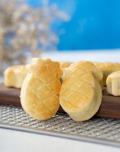 Freshly baked pineapple-shaped dinner rolls cooling on a wire rack, showcasing soft golden bread perfect for catered events by Bites of Charleston in Charleston, SC.
