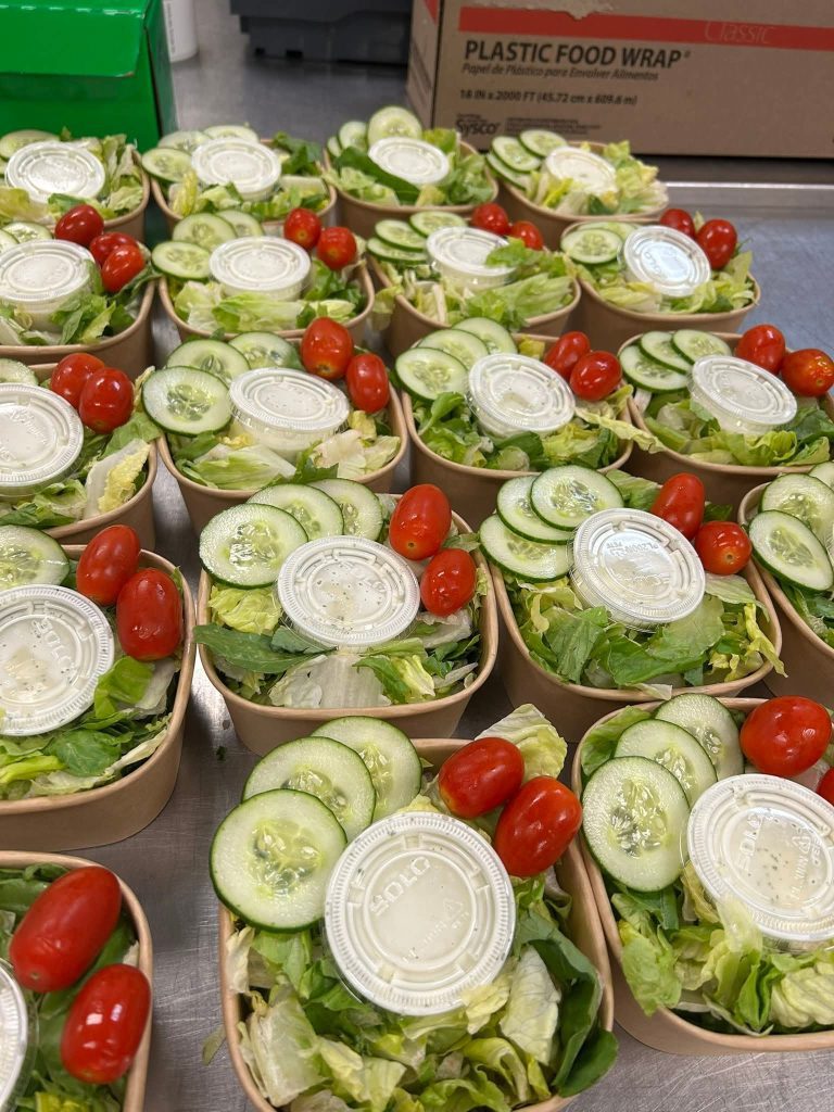 Fresh garden salad boxed lunches with cucumbers, grape tomatoes, and ranch dressing prepared for corporate catering in Charleston SC.