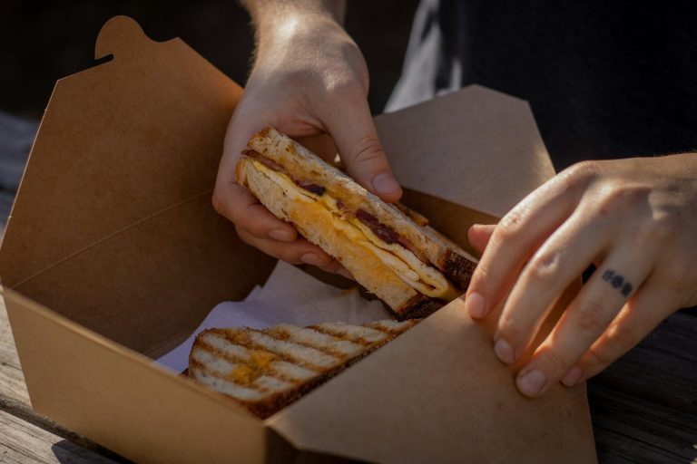 Fresh breakfast sandwich with eggs, cheese, and bacon packaged in a convenient takeout box by Bites of Charleston, perfect for corporate breakfasts and grab-and-go catering in Charleston, SC.