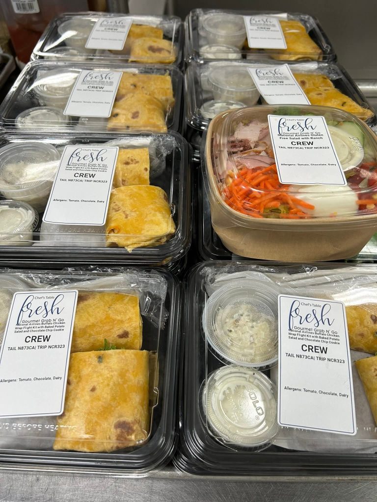 Fresh individually packaged in-flight meals including gourmet wraps, salads, sides, and desserts prepared for private jet and charter flight catering in Charleston SC.
